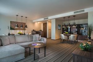 a living room and kitchen with a couch and a table at Premier Sofia Airport Hotel in Sofia