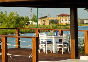 a table and chairs on a deck with a view of the water at BlackSeaRama Golf & Villas in Balchik