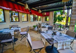 um restaurante com mesas e cadeiras num quarto em BlackSeaRama Golf & Villas em Balchik