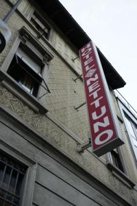 a red sign on the side of a building at Hotel Nettuno in Milan