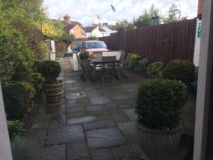 un patio con mesa, sillas y una valla en Bay Lodge en Aylesbury