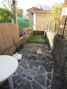 a stone walkway with a white table and a fence at Appartamento Da Loreno in Cutigliano