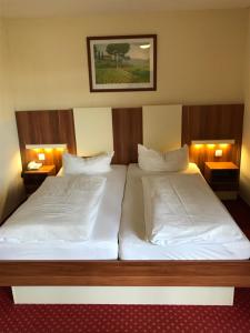 duas camas num quarto de hotel com duas lâmpadas em Central Hotel-Apart München em Munique