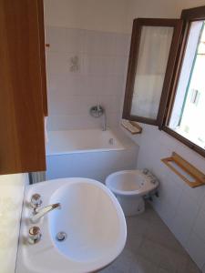 a bathroom with a sink and a tub and a toilet at Appartamento Da Loreno in Cutigliano