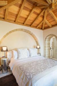 En eller flere senger på et rom på Moni Emvasis Luxury Suites