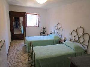a room with three beds with green sheets at Appartamento Da Loreno in Cutigliano