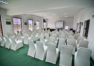 an empty room with white chairs and a screen at Club Residence at BlackSeaRama Golf in Balchik +76 photos