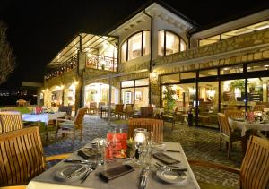 a restaurant with tables and chairs in front of a building at Club Residence at BlackSeaRama Golf in Balchik