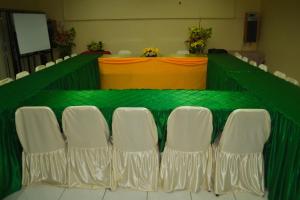 a green and white table with white chairs in a room at Hotel Indra Toraja in Rantepao