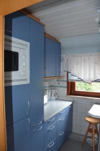 eine Küche mit blauen Schränken und einer Mikrowelle in der Unterkunft Ferienwohnung Westphal in Eschwege