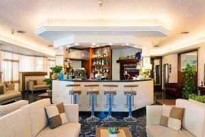 a lobby with a bar with bar stools at Hotel Ariston in Bibione