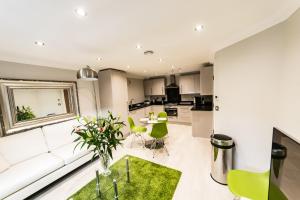 a living room with a white couch and green chairs at Malthouse Court in Reading