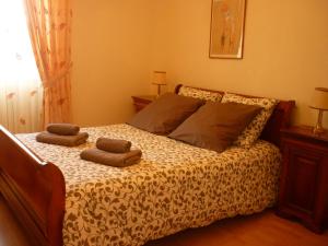 ein Schlafzimmer mit einem Bett mit zwei Kissen darauf in der Unterkunft Maison dans la cité médiévale de Domme in Domme