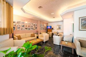 un soggiorno con divani, tavoli e TV di Hotel Ariston a Bibione