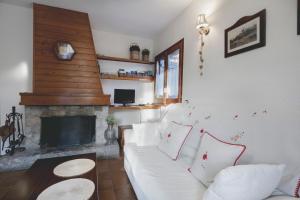 sala de estar con sofá blanco y chimenea en La Ginesta, en Taüll