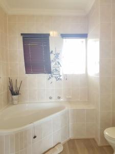 a bathroom with a tub and a toilet and a window at Point Village Accommodation - Ocean Two 42 in Mossel Bay