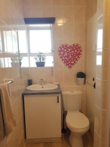 a bathroom with a toilet and a sink with a heart on the wall at Point Village Accommodation - Ocean Two 42 in Mossel Bay