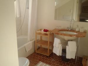 a bathroom with a sink and a toilet and a tub at Sonnwirtstöckl am See in Sankt Gilgen