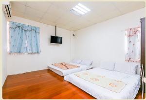 台東市的住宿－小古民宿  ，一间卧室配有两张床和一台平面电视