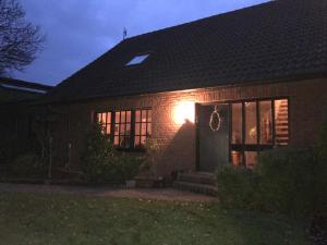 ein Backsteinhaus nachts mit Licht an der Tür in der Unterkunft Ferienwohnung am Komisenpad in Südlohn