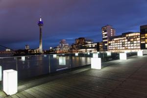 a boardwalk with a view of a city at night at Berolina Haus in Düsseldorf