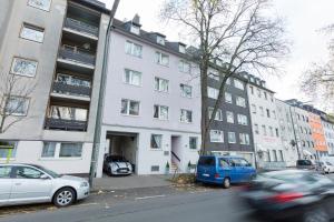 un edificio blanco con coches estacionados frente a él en Berolina Haus en Düsseldorf