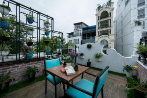 a patio with a table and chairs and potted plants at Hanoi La Selva Hotel in Hanoi