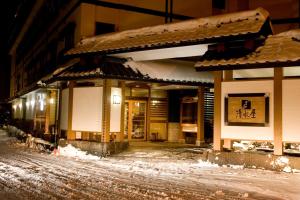 a building on a snowy street at night at Oyado Kiyomizuya in Noboribetsu