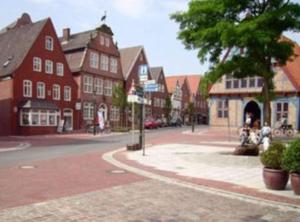 eine Straße in einer kleinen Stadt mit roten Gebäuden in der Unterkunft Feriendomizil im Musikerviertel in Otterndorf in Otterndorf