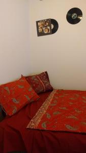 a bed with a red comforter and a record at VINYL House. A quiet street in the centre of city in Târgu-Mureş