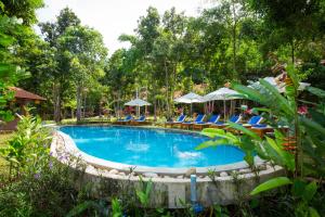 a swimming pool with chairs and umbrellas at Valley Village Resort Phu Quoc in Phú Quốc