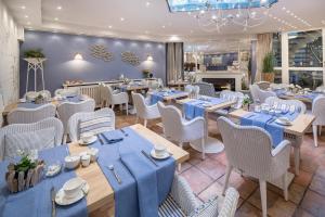 un restaurante con mesas azules y sillas blancas en Villa Ney, en Norderney