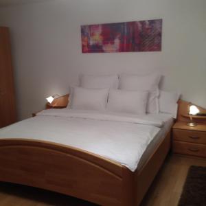 um quarto com uma cama com lençóis brancos e almofadas em Xenopol Grand Studio em Sibiu