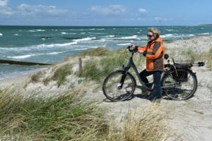 グロヴェにあるHaus am Meer Ostsee Insel Rügen Fischerweg 3 Wlanの海岸の自転車に腰掛けている男