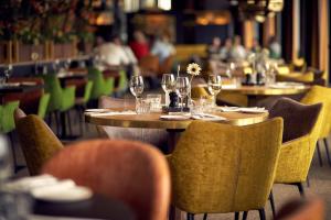 un restaurante con mesas y sillas y copas de vino en Van der Valk Hotel Rotterdam Ridderkerk en Ridderkerk