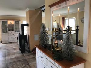 ein Wohnzimmer mit Weihnachtsbäumen auf einer Theke in der Unterkunft Reethaus Deichgraf erste Reihe HERRL Wasserblick WLAN  drei in Breege + 23 Fotos