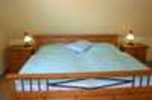 Schlafzimmer mit einem Bett mit blauer Tagesdecke in der Unterkunft Reethaus Deichgraf erste Reihe HERRL Wasserblick WLAN  drei in Breege