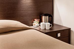 a bed with two cups and a coffee maker on a night stand at Muà Boutique Bologna in Bologna