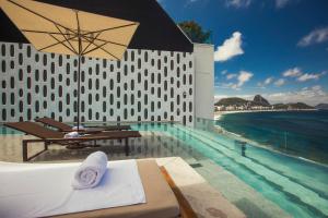 a swimming pool with a table and an umbrella at Emiliano Rio in Rio de Janeiro