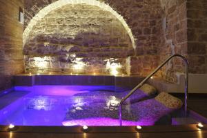 a hot tub with lights in a room with a brick wall at Hotel Corte Altavilla in Conversano