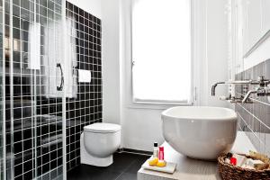 ein Badezimmer mit einer Badewanne, einem WC und einem Waschbecken in der Unterkunft Muà in Bologna