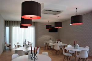 a restaurant with white tables and chairs and red lights at Ansiturismo Alojamento in Ansião