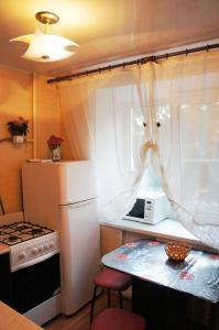 トムスクにある1комнатная до 4 чел на Железнодорожной 1の小さなキッチン(白い冷蔵庫、テーブル付)