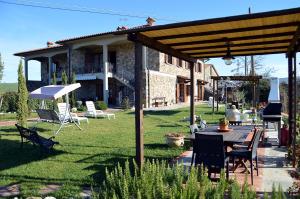 patio ze stołem i krzesłami oraz dom w obiekcie Agriturismo La Spiga w mieście Montecatini Val di Cecina