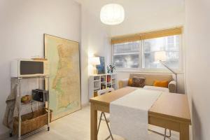 een woonkamer met een tafel en een kaart aan de muur bij white fabrica house in Porto