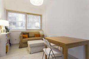 een woonkamer met een tafel en een bank bij white fabrica house in Porto
