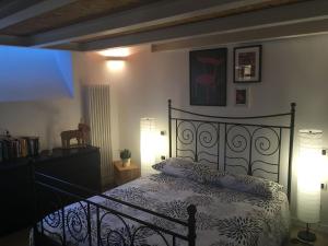 アオスタにあるMaison Grivon Chalet nel Borgo di Charvensodのベッドルーム1室(黒いベッド1台、ランプ2つ付)