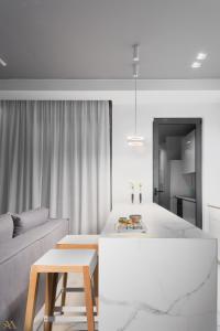 a white living room with a couch and a table at Elysium Boutique Apartments in Athens
