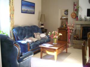 Sala de estar con sofá azul y mesa de centro en Chambres d'Hôtes La Loubatais en Dol-de-Bretagne