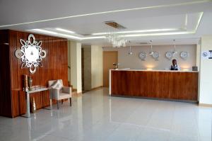 a man standing at a reception desk in a lobby at Blu Sky Hotel in Maputo